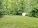 Well-maintained backyard with a storage shed and a lush green lawn surrounded by mature trees at 12317 Panthersville Dr, Charlotte, NC 28269