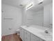 Bright bathroom has wood floor, double sinks, a toilet, and a large mirror at 12317 Panthersville Dr, Charlotte, NC 28269