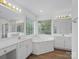 Bright bathroom boasts double vanity, large tub, and natural light from a large window at 12317 Panthersville Dr, Charlotte, NC 28269
