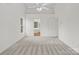 Spacious bedroom with neutral carpet and ceiling fan leading to ensuite bathroom at 12317 Panthersville Dr, Charlotte, NC 28269