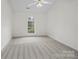 Light bedroom with neutral carpet, modern ceiling fan, and an arched window at 12317 Panthersville Dr, Charlotte, NC 28269