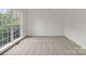 Bright bedroom with a large window providing natural light and neutral carpet at 12317 Panthersville Dr, Charlotte, NC 28269