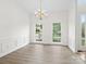 Formal dining room with elegant chandelier, wainscoting, and natural light at 12317 Panthersville Dr, Charlotte, NC 28269