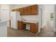Functional kitchen with cabinetry, a workstation, a refrigerator, and wood-look flooring at 12317 Panthersville Dr, Charlotte, NC 28269