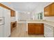 Bright kitchen with white appliances, wood cabinets, open layout, and eat-in bar at 12317 Panthersville Dr, Charlotte, NC 28269