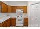 Traditional kitchen with wood cabinets, white appliances, and light countertops at 12317 Panthersville Dr, Charlotte, NC 28269