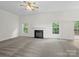 Spacious living room with carpet, fireplace, and plenty of natural light from the windows at 12317 Panthersville Dr, Charlotte, NC 28269