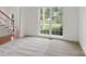 Spacious living room featuring a large window with a view of the landscaped yard and patterned carpet at 12317 Panthersville Dr, Charlotte, NC 28269