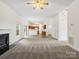 Spacious living room with fireplace, open to kitchen area, and staircase in view at 12317 Panthersville Dr, Charlotte, NC 28269