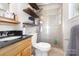 Updated bathroom featuring a glass door shower and floating wood shelves at 1407 Jodhpur Ct, Charlotte, NC 28212