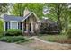 Charming home featuring a brick chimney and inviting front entrance enveloped by lush greenery at 1407 Jodhpur Ct, Charlotte, NC 28212