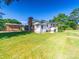 Spacious backyard featuring a well-maintained lawn, storage sheds, and mature trees, ideal for outdoor enjoyment at 1468 Hilltop St, Albemarle, NC 28001