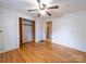 Bedroom featuring hardwood floors, closet, and view of the hallway to other rooms of the home at 1468 Hilltop St, Albemarle, NC 28001