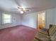 Bedroom with a ceiling fan and pink carpet, plus access to the bathroom at 1468 Hilltop St, Albemarle, NC 28001