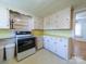 Bright eat-in kitchen with white cabinets and a black and stainless range at 1468 Hilltop St, Albemarle, NC 28001