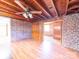 Spacious living room featuring wood ceiling, brick wall, and laminate floors at 1468 Hilltop St, Albemarle, NC 28001