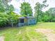 Exterior view of a storage shed in the backyard, overgrown with greenery at 1468 Hilltop St, Albemarle, NC 28001