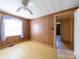 A bedroom with wood paneling, window, and a ceiling fan at 1470 Hilltop St, Albemarle, NC 28001