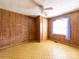 A bedroom with wood paneling, laminate flooring, and a ceiling fan at 1470 Hilltop St, Albemarle, NC 28001