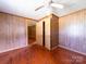 A bedroom featuring wood paneling, hardwood floors, and a ceiling fan at 1470 Hilltop St, Albemarle, NC 28001