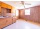 Retro kitchen featuring wood paneling, classic cabinets and vintage ceiling fan at 1470 Hilltop St, Albemarle, NC 28001