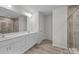 Bright bathroom featuring a double sink vanity, tiled floors, and a glass-enclosed shower at 1601 Calder Dr, Indian Trail, NC 28079