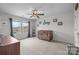 Well-lit Bedroom with a wooden crib, grey curtains, and view of neighborhood at 1601 Calder Dr, Indian Trail, NC 28079