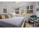 Well-lit bedroom with a large bed, a ceiling fan, a window, and wall art, along with a functional desk area at 1601 Calder Dr, Indian Trail, NC 28079