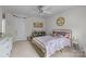 Cozy bedroom featuring a gold metal bed frame, ceiling fan, carpeted floors, and natural light from the window at 1601 Calder Dr, Indian Trail, NC 28079