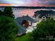Stunning waterfront home with lush landscaping and panoramic lake views at twilight at 16108 Woolwine Rd, Charlotte, NC 28278
