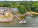 Breathtaking aerial view of a luxurious lakefront property with docks and sandy beach at 16108 Woolwine Rd, Charlotte, NC 28278