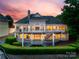 Expansive rear exterior with multiple decks offers stunning views at sunset at 16108 Woolwine Rd, Charlotte, NC 28278