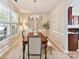 Cozy dining room featuring chair rail, a chandelier, and a large window at 17204 Caldwell Track Dr, Huntersville, NC 28078