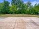 Stamped concrete back patio featuring a lawn and a row of mature trees in the background at 1723 Loggerhead Dr, Lancaster, SC 29720
