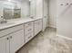Well-lit bathroom with double vanity, tiled floors, and a glass-enclosed shower at 1723 Loggerhead Dr, Lancaster, SC 29720