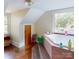 Bright bathroom featuring a built-in tub, multiple windows, and tile accents at 208 N 5Th St, Albemarle, NC 28001