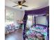 Bright bedroom featuring a four-poster bed with whimsical purple canopy, and ceiling fan at 208 N 5Th St, Albemarle, NC 28001