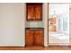 Charming built-in cherry cabinet with black countertop complements the adjacent light-filled kitchen and breakfast area at 2310 Vestry Pl, Charlotte, NC 28270