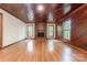 Charming living room with hardwood floors, a brick fireplace, wood-paneled walls, and lots of windows at 2310 Vestry Pl, Charlotte, NC 28270