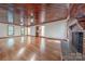 Spacious living room with hardwood floors, a brick fireplace, wood-paneled walls, and natural light at 2310 Vestry Pl, Charlotte, NC 28270