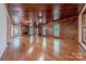 Spacious living room with wood-paneled walls, hardwood floors, and a charming brick fireplace at 2310 Vestry Pl, Charlotte, NC 28270