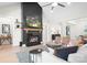 Bright living room with a tall black fireplace, light wood flooring, and contemporary furnishings at 2396 Lee Lawing Rd, Lincolnton, NC 28092