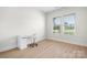 Minimalist office space featuring light wood flooring, a white desk and chair, and natural light at 2396 Lee Lawing Rd, Lincolnton, NC 28092