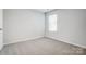 A bright carpeted bedroom with a window and neutral walls at 2405 Hedgecliff Rd, Kannapolis, NC 28025