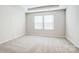 Neutral bedroom featuring carpeted floors, large windows, and a tray ceiling at 2405 Hedgecliff Rd, Kannapolis, NC 28025