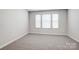 Neutral carpeted bedroom featuring three windows to provide natural light at 2405 Hedgecliff Rd, Kannapolis, NC 28025