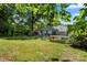 Open backyard featuring grassy lawn, play equipment, and mature trees at 2635 Clover Hill Ln, Charlotte, NC 28215