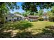 Large backyard with patio, green grass, play equipment, and mature trees at 2635 Clover Hill Ln, Charlotte, NC 28215