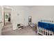 Bedroom with a white crib, reading chair, closet, and natural light at 2635 Clover Hill Ln, Charlotte, NC 28215