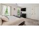 Bright bedroom features neutral colors, plush carpet, and a large TV at 2635 Clover Hill Ln, Charlotte, NC 28215